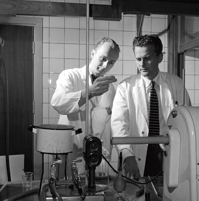 Figur 1  Lorentz Eldjarn (t.h.) og Alexander Pihl i laboratoriet i 1955. «Deres arbeid med strålebeskyttende stoffer har…