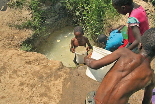 Figur 2  Barn henter vann fra en brønn i Harare, desember 2008. Foto AP/Scanpix