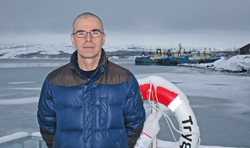 Jostein Tørstad trygt plassert med en livbøye ved sin side. I bakgrunnen skimtes et knippe russiske fisketrålere. Foto…