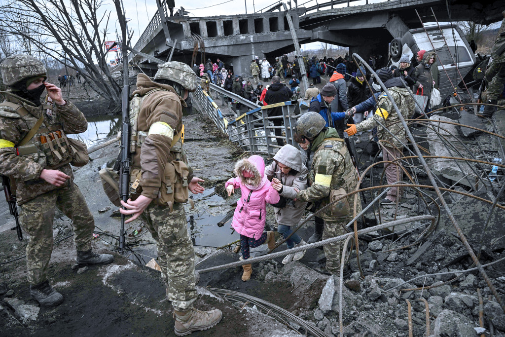 Folk krysser en &oslash;delagt bro under evakueringen av Irpin, nordvest for Kyiv, i bomberegn 5.&nbsp;mars 2022. Illustrasjonsfoto:&hellip;
