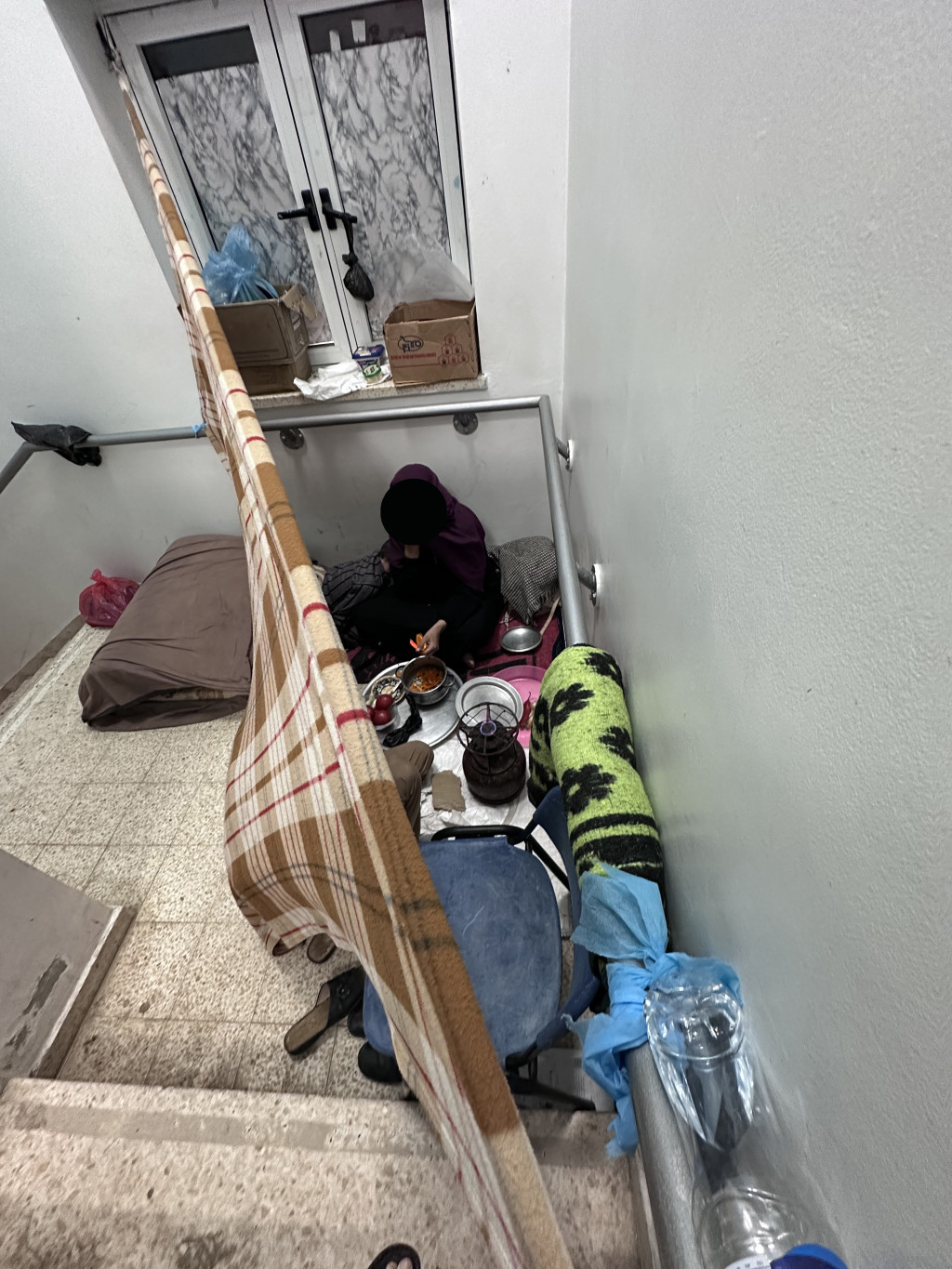 Kvinne som lager mat i sykehustrappen på European Gaza Hospital. Foto: Geir Stray Andreassen.