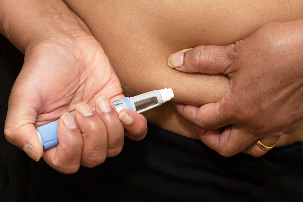 Kvinnelig pasient som bruker en ferdigfylt penn for å injisere diabetesmedisinen semaglutid på seg selv. Illustrasjon:…