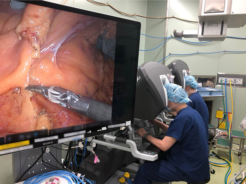 Figur 1 Robotkirurgi med to konsoller ved Cancer Institute Hospital i Tokyo. En erfaren operatør (proktor) underviser en…