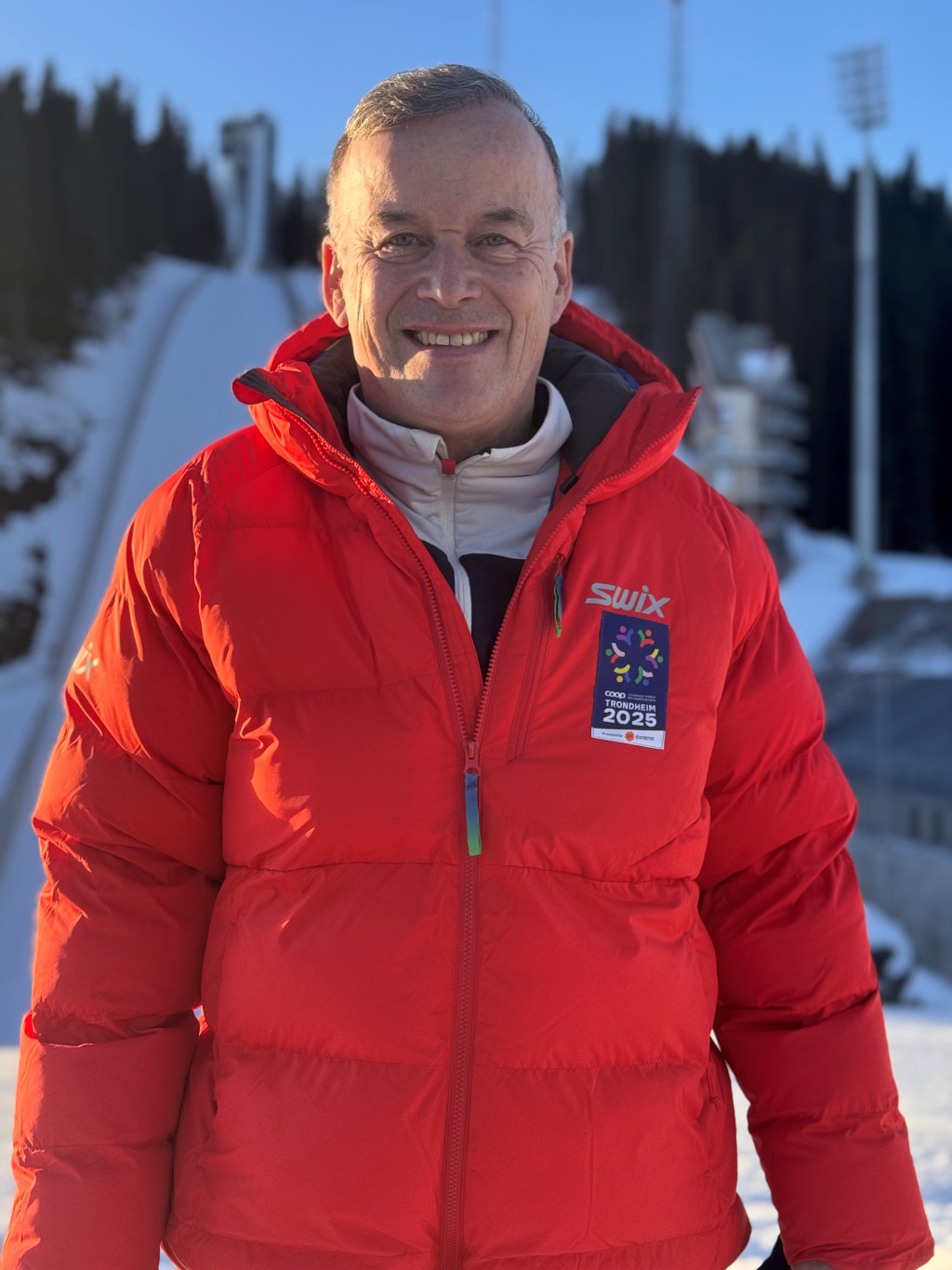 MEDISINSK VM-SJEF: Jon Olav Drogset i funksjonærjakke foran hoppbakken i Granåsen. VM på ski pågår i år fra 26. februar til…